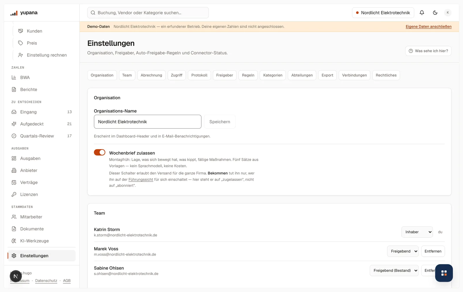 Die Einstellungen mit der Sprungleiste über Organisation, Team, Abrechnung, Zugriff, Protokoll, Freigeber, Regeln, Kategorien, Abteilungen, Export, Verbindungen und Rechtliches, darunter der Organisationsname und der Schalter für den Wochenbrief.